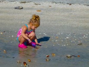 little girl digging beach sand