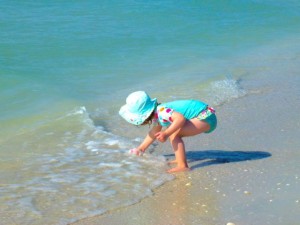 young child on beach shells