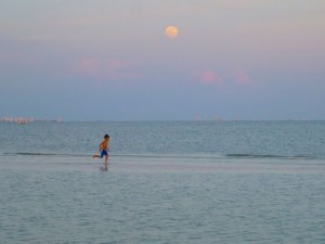 boy running full moon sanibel